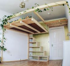 the loft bed is made from wood and has plants growing on it