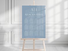 an easel with a wedding seating chart on it in front of a white wall