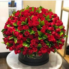 a large bouquet of red roses sitting on top of a table