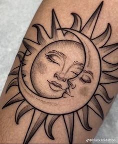 a sun and moon tattoo design on the left arm, with two faces in the center