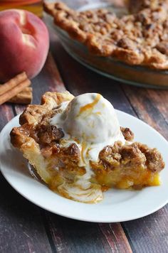 a slice of apple pie on a plate with ice cream and cinnamon sticks next to it