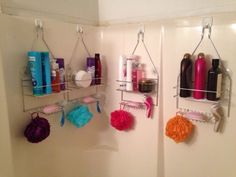 two shower shelves with hair products and other items hanging on the wall in a bathroom