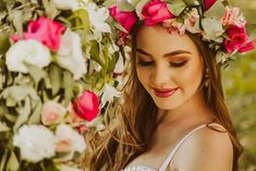 a woman with flowers in her hair and wreath around her head looking at the camera