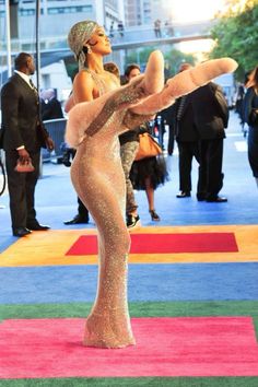 a woman standing on top of a colorful carpet next to a man in a suit