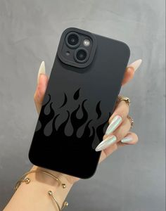 a woman's hand holding up a black phone case with flames painted on it