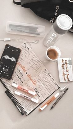 the contents of a purse are laid out on top of a table next to a cup of coffee