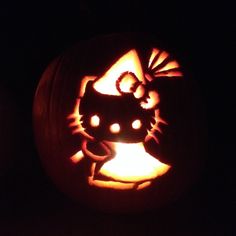 a carved pumpkin with an image of a cat on it's face in the dark