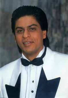 a man in a white tuxedo and black bow tie