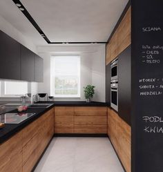 a kitchen with black counter tops and wooden cabinets, along with chalk writing on the wall