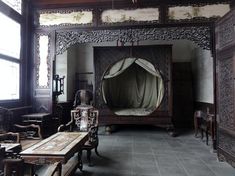 an old room with wooden furniture and large mirrors on the wall, along with other antique furnishings