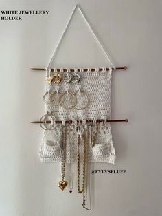 a crocheted wall hanging with lots of rings and chains attached to the hooks