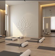 there are many yoga mats on the floor in front of a wall with a lotus symbol