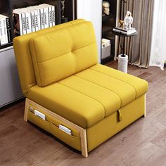 a yellow chair sitting on top of a hard wood floor next to a book shelf