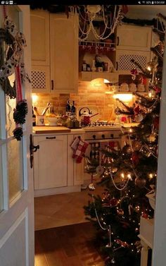 a decorated christmas tree in the corner of a kitchen