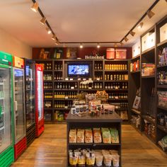 the inside of a grocery store with many items on shelves and food in glass cases