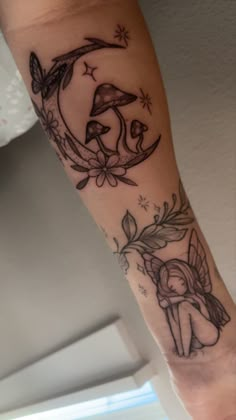 a woman's arm with tattoos on it and an image of a fairy sitting on the moon