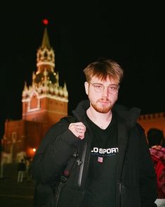 a man standing in front of a castle at night