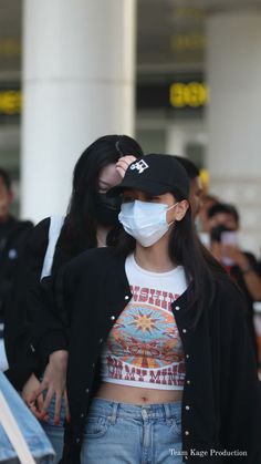 a woman wearing a face mask while walking through an airport