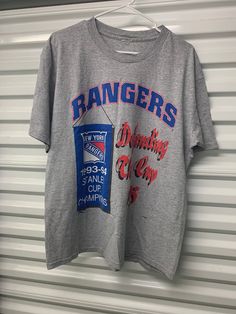 a t - shirt hanging on a garage door with the word rangers printed on it