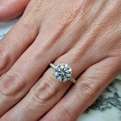 a woman's hand with a diamond ring on it