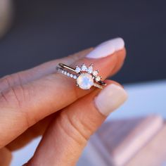 a woman's hand holding an engagement ring in her left hand and diamond band