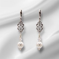 Elegant Art Deco, Edwardian style drop earrings with antiqued silver connector and lever back ear wires, gracefully show the stunning white pearl glass bead and dainty clear crystal bicone bead,  Capturing the grace of the Bridgerton period these earrings would complement any dress occasion, from your special day to casual wear.  Each earrings has a 55mm drop. Classic Bridal Earrings For Evening, Elegant Nickel-free Drop Bridal Earrings, Elegant Nickel-free Sterling Silver Bridal Earrings, White Victorian Earrings For Formal Occasions, Victorian Style White Earrings For Formal Occasions, Classic Filigree Earrings, Victorian Style Pierced Earrings For Wedding, Classic Silver Jewelry With French Hook, Vintage Sterling Silver Chandelier Earrings For Wedding