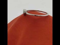 an orange bag with a silver ring on it's handle and the bottom part of the bag is empty