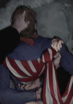 the man is wrapped up in an american flag shirt and tie while sitting on his stomach