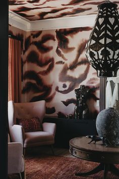 a living room filled with furniture next to a wall covered in animal print on the walls