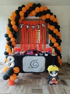 an orange and black birthday party with balloons, streamers, decorations and table cloths