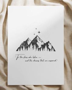 a card with an ink drawing of mountains and stars