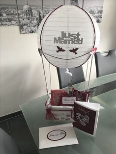 a hot air balloon sitting on top of a glass table next to a greeting card