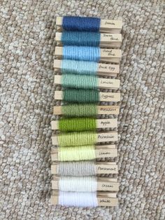 six skeins of different colors of yarn sitting on top of a rug next to each other