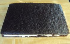 a piece of black cake sitting on top of a wooden table