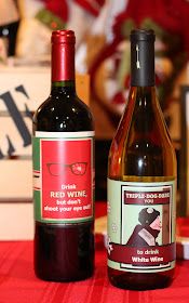 two bottles of wine sitting on top of a red table cloth covered table with other items