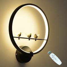 two birds sitting on a wire in front of a mirror with a remote control next to it