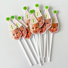 a set of six birthday candles with pictures of babies on them and green top hats