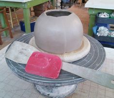 a large clay pot sitting on top of a table next to a pair of scissors