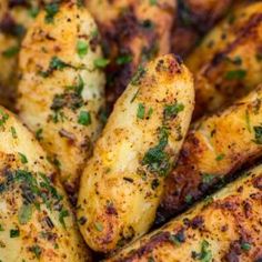 grilled potatoes with herbs and seasoning in a blue bowl on a white table