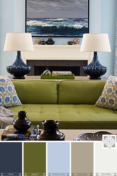 a living room with green couches and blue walls in the color scheme, along with two lamps on either side of the couch