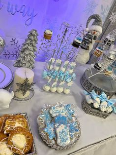 a table topped with cakes and desserts covered in frosted icing next to snowflakes