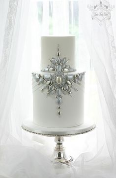 a white cake with silver decorations on it