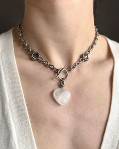 The necklace is handmade from a hefty stainless steel chain and a white translucent heart made of natural quartz. If you need a different length for the accessory, please write to me about it. DIMENSIONS & FEATURES: ▪️ Materials: Natural stone quartz and stainless steel (hypoallergenic and maintains its appearance over time) ▪️ Color: silver metal and white ▪️ Length options:  39 cm / 15,3 inch 41 cm / 16,1 inch 43 cm / 16,9 inch 45 cm / 17,7 inch 47 cm / 18,5 inch Choose your desired length from the drop-down menu during checkout. ▪️ Weight: ~28g / ~1 oz (length 39 cm) PACKAGE & SHIPPING: ▪️ ECO-friendly packing. I draw inspiration from nature and strive to minimize environmental impact. ▪️ FREE shipping ▪️ Ready to ship in 1-2 business days ▪️ I send all orders by priority parcel with tr White Heart-shaped Metal Chain Necklace, Linen Pouch, Bold Statement Jewelry, Toggle Necklace, Photo Dimensions, Heart Shape Pendant, Chunky Necklace, Steel Necklace, Short Necklace