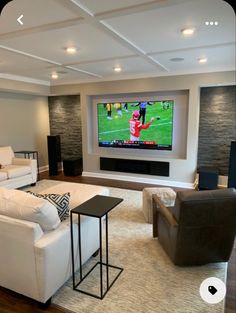 a living room filled with furniture and a flat screen tv mounted to the side of a wall