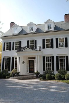 a large white house with black shutters on the front