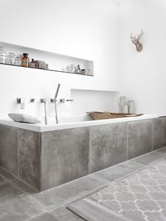 a bath room with a large tub and a shelf on the wall next to it