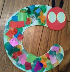 a paper plate wreath made to look like a caterpillar on a wooden table