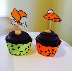 two decorated cupcakes sitting on top of a table