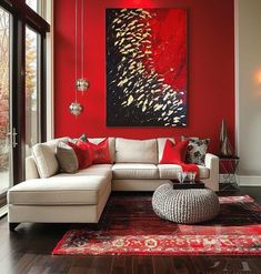 a living room with red walls, white couches and large painting on the wall