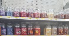 there are many different colored jars on the shelf